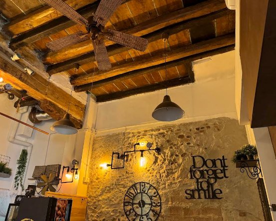 Soffitto con travi in legno massello, lampada industrial e muro pietra — architettura autentica ristorante pasta fresca Bologna